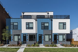 A row of modern blue, white, and gray rental homes, where Walters & Company might provide professional Denver property management